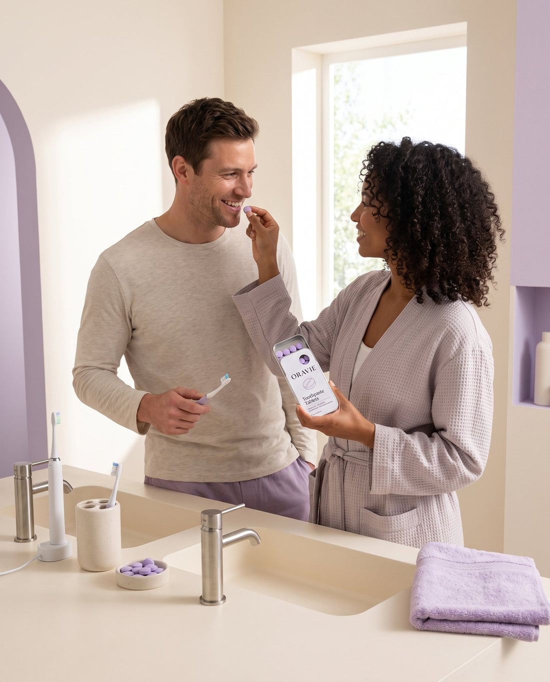 Couple sharing ORAVIE Toothpaste Tablets during their morning routine at the bathroom sink