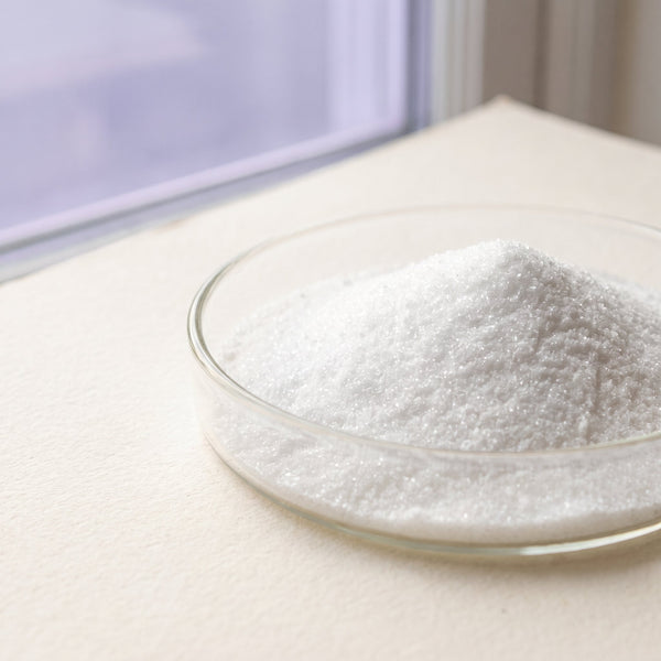 Fine white crystalline powder in a glass dish